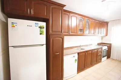 a kitchen with a white refrigerator and wooden cabinets at Nomadia turkey in Istanbul