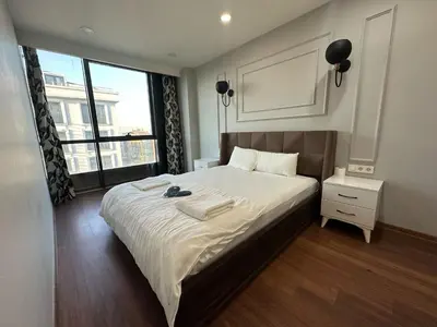 a bedroom with a large bed and a large window at Gold Suit in Istanbul