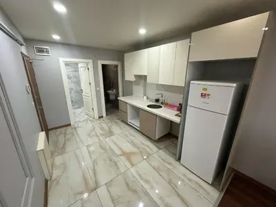 a kitchen with white cabinets and a white refrigerator at Gold Suit in Istanbul