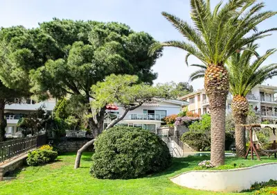 two palm trees in front of a building at Villa Büyükada I Private Pier & Seawater Pool in Istanbul