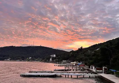 a sunset over a body of water with boats at Villa Büyükada I Private Pier & Seawater Pool in Istanbul