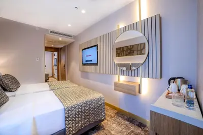 a hotel room with a bed and a mirror at Lions Royal Hotel in Istanbul