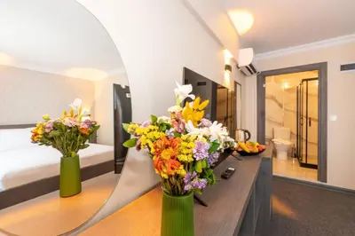 two vases filled with flowers on a table in a room at Mays Otel in Istanbul
