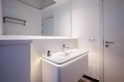 a white bathroom with a sink and a mirror at Stunning Serene 2BD1Bath Bosphorus Retreat! #400 in Istanbul