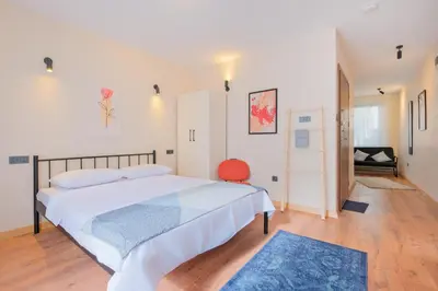 a bedroom with a large white bed and a red chair at Casa Nozze 2 in Istanbul