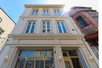 a tall white building with the sun shining on it at Balatella Suites in Istanbul