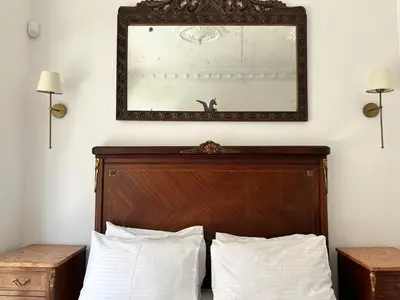 a mirror above a bed with two pillows at Balatella Suites in Istanbul