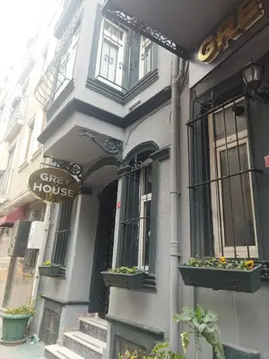 a white building with a gate house sign on it at Grey House Apartments B Block in Istanbul