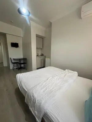 a bedroom with a large white bed and a table at Şişli Suites - Room25 in Istanbul