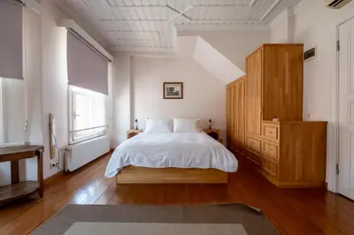 a bedroom with a white bed and a wooden cabinet at House with Terrace in Sultanahmet in Istanbul