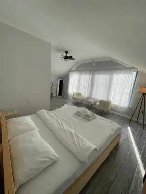 a large white bed in a room with chairs at Villa akça in Kartepe