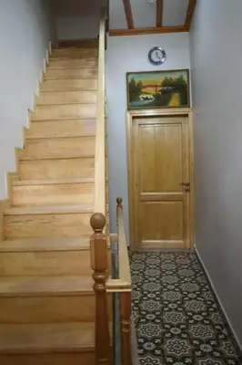 a hallway with a wooden door and stairs with a clock on the wall at 3 Floor History Mansion in Istanbul
