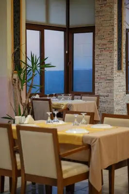 a dining room with tables and chairs and windows at CANPOLAT Sapanca Hotel in Sapanca