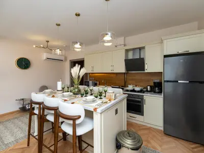 a kitchen with a table with chairs and a refrigerator at sevim suites Nişantaşı Rumeli in Istanbul