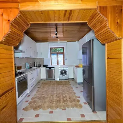 a kitchen with white appliances and a wooden ceiling at Uludag Nefes Echoes by the Woods in Uludag