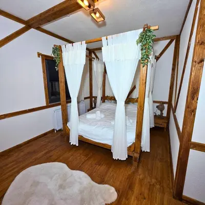 a bedroom with a canopy bed with white curtains at Uludag Zirve Garden - BBQ Jacuzzi