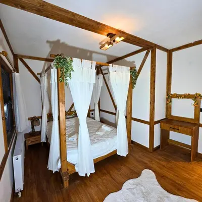 a bedroom with a canopy bed with white curtains at Uludag Zirve Garden - BBQ Jacuzzi