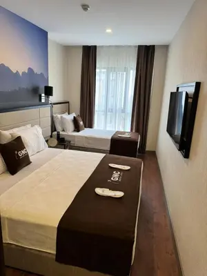 a hotel room with two beds and a flat screen tv at Gnc Airport Hotel in Arnavutköy