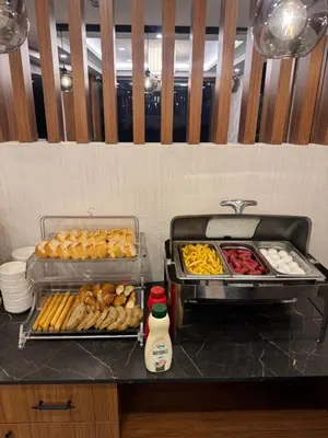 a buffet with trays of food on a counter at Gnc Airport Hotel in Arnavutköy