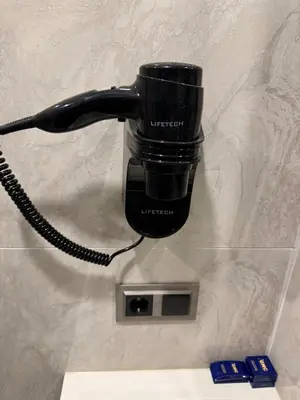 a black phone hanging on a wall at Gnc Airport Hotel in Arnavutköy