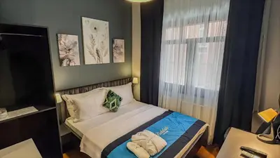 a small bedroom with a bed and a window at Balat Side Apart in Istanbul