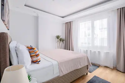 a white bedroom with a bed and a window at Newly Built in Sisli • Fast WiFi • Elevator in Istanbul
