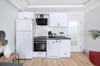 a kitchen with white cabinets and a white refrigerator at Newly Built in Sisli • Fast WiFi • Elevator in Istanbul