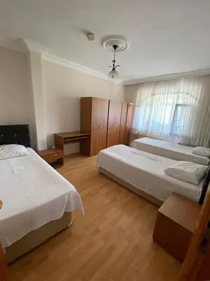 a bedroom with two beds and wooden floors at bahçeli ve göl manzaralı ev in Sapanca