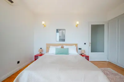 a white bedroom with a large bed with two red tables at Bosphorus View with 5 Bedrooms and Elevator in Istanbul
