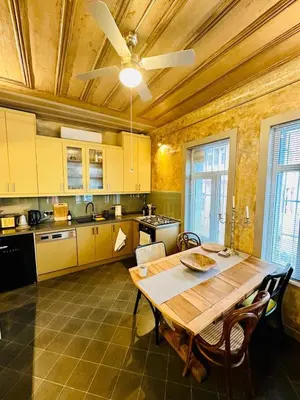 a kitchen with a wooden table and a ceiling fan at Balat Istanbul Three-Story Restored Ottoman House in Istanbul