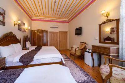 a hotel room with two beds and a mirror at Hotel Gedikpasa Family in Istanbul