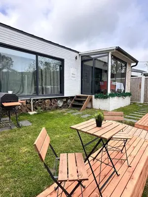 a wooden deck with a picnic table and chairs at Ağva Nehir Kenarı TinyHouse Jakuzili in Sile