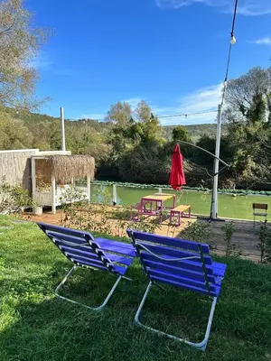 two blue chairs sitting in the grass in a yard at Ağva Nehir Kenarı TinyHouse Jakuzili in Sile
