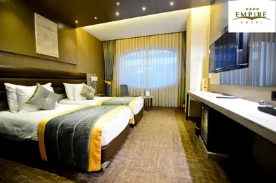 a hotel room with two beds and a sink at Empire Hotel İstanbul in Istanbul