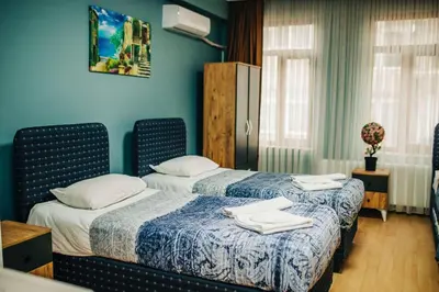 two beds in a room with blue walls at Ekinoks Hotel in İznik