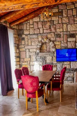 a dining room with a wooden table and red chairs at Ekinoks Hotel in İznik