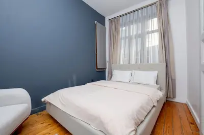a bedroom with a bed with a blue wall and a window at Private Building Featuring Two Separate Apartments in Istanbul