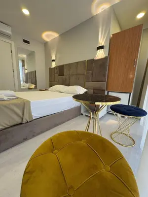 a bedroom with a large bed with a table and a chair at Mall Off Palace in Istanbul