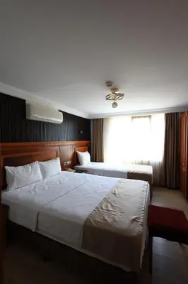 a hotel room with two beds and a window at New House Hotel in Istanbul