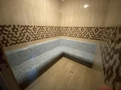 a bathroom with a shower with a blue tile floor at Alrazi Hotel in Istanbul
