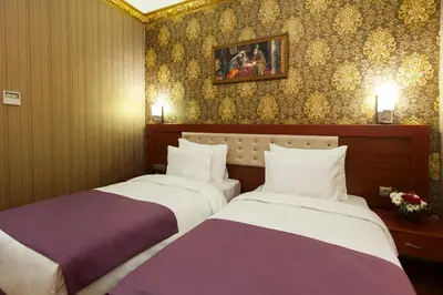 a hotel room with two beds and a painting on the wall at Alrazi Hotel in Istanbul