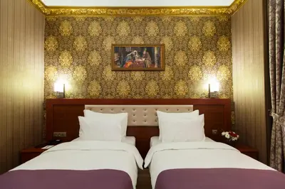 two beds in a hotel room with a wall at Alrazi Hotel in Istanbul