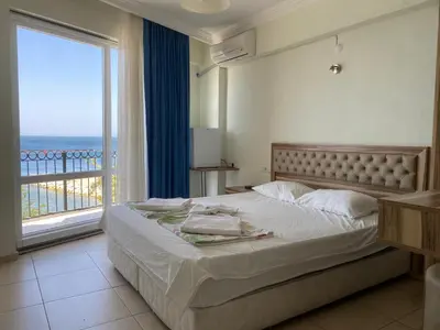 a bedroom with a large bed and a large window at Sato Hotel in Marmara