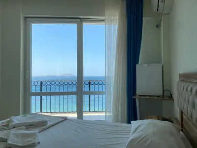 a bedroom with a bed and a large window at Sato Hotel in Marmara