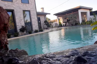 a swimming pool in front of a house at maura beach villas family in Kartepe