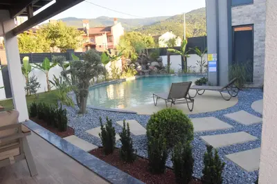 a backyard with a swimming pool and a patio at maura beach villas family in Kartepe