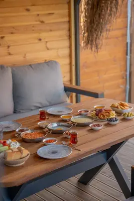 a wooden table with many plates of food on it at Armoni Life Bungalov in Yanık