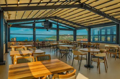 a restaurant with tables and chairs and windows at Rest By Dedeman Sapanca in Sapanca