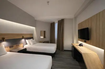 a hotel room with two beds and a television at Rest By Dedeman Sapanca in Sapanca