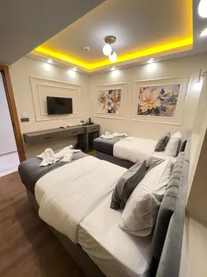 two beds in a room with a tv on the wall at City Hotel İstanbul in Istanbul